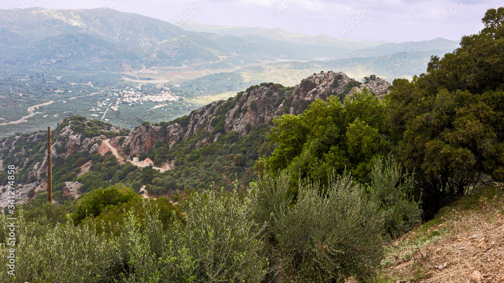 view from the mountain to a small Cretan town on a background of gray cloudy sky