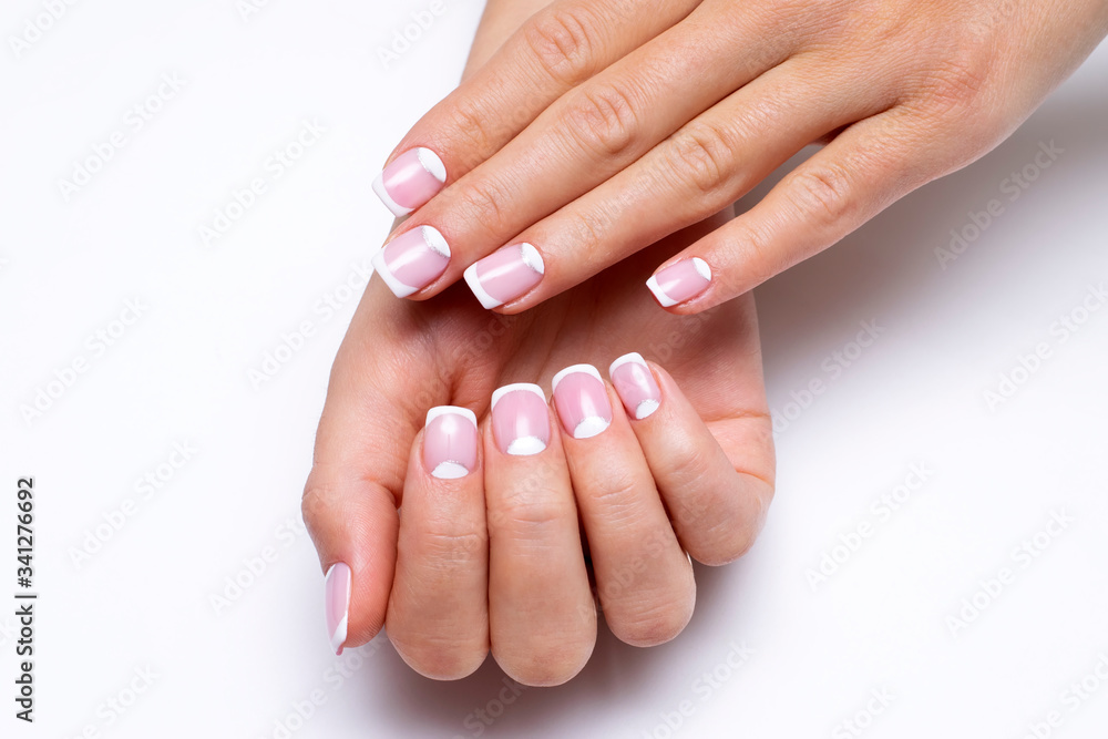 Wedding french white manicure on short square nails with a white hole and silver sparkles closeup on a white background
Wedding french white manicure on short square nails with a white hole and silver sparkles closeup on a white background