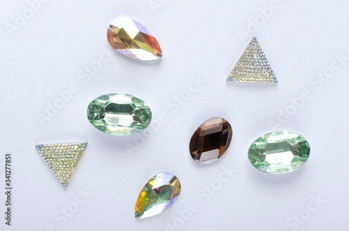 Top view of beautiful decorative stones on the white background.Shiny diamond imitation  