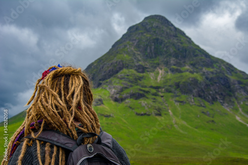 Rastafarian girl looks at a mountain photo