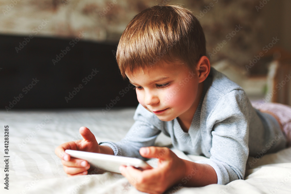 cute kid playing games on smartphone at home. cute kid playing games on smartphone at home.
