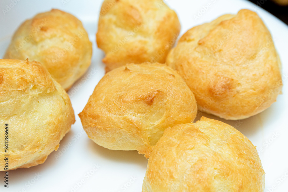 homemade profiteroles on a white plate close up homemade profiteroles on a white plate close up