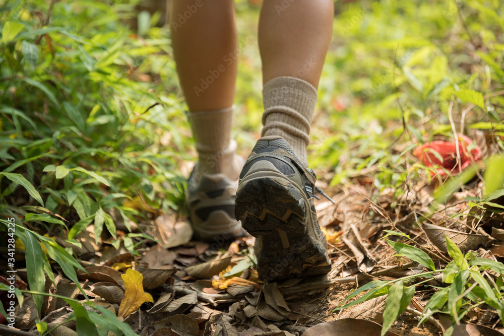 Woman hiker legs walking on trail in spring mountains Woman hiker legs walking on trail in spring mountains