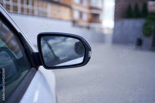 Side rearview mirror of a modern car in city.