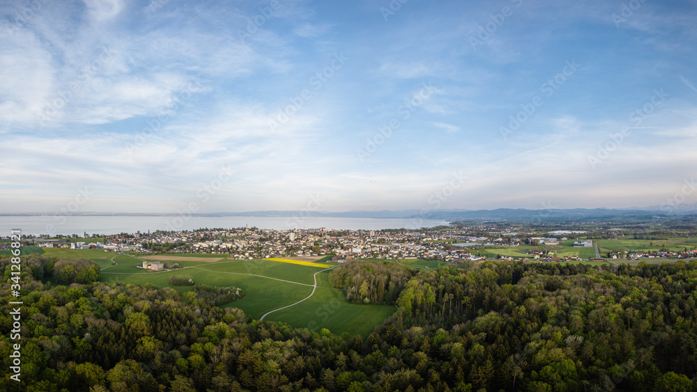 Fototapeta premium Romanshorn and the lake of Constance from high above the forrest