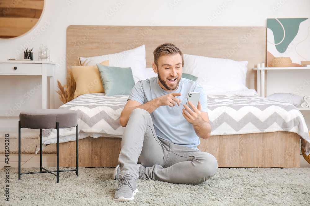 Young man with mobile phone video chatting at home Young man with mobile phone video chatting at home