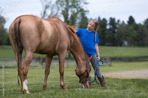 Young girl grazing her horse.