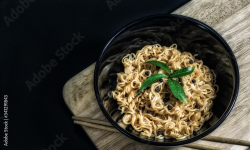 Instant noodles in a bowl on a black background