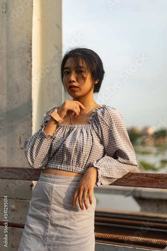 A young beautiful girl poses on an old bridge. © Martisz Media