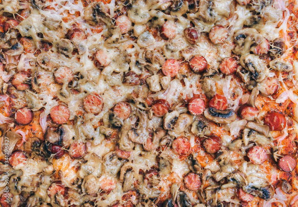 Pizza with sausages and mushrooms, onions and tomato paste. Close up, top view. Stage of preparation before sprinkling with cheese. Pizza with sausages and mushrooms, onions and tomato paste. Close up, top view. Stage of preparation before sprinkling with cheese.