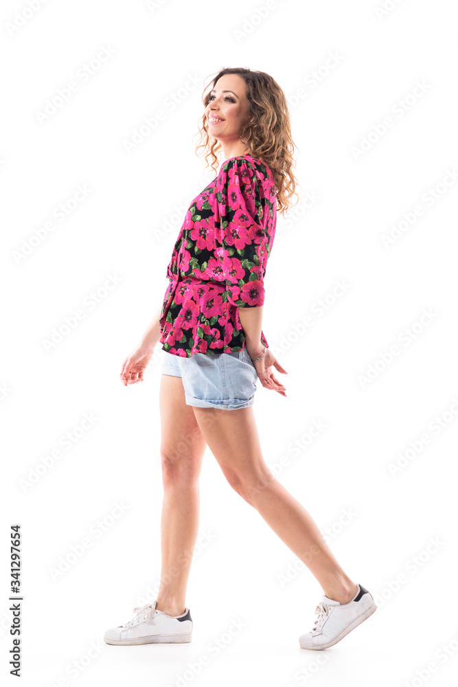 Side view of happy confident young woman in summer casual clothes walking carefree looking away. Full body isolated on white background. 