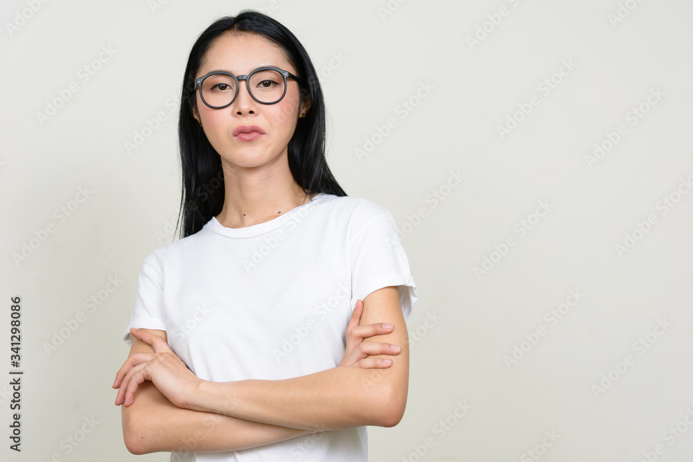 Obraz premium Young beautiful Asian nerd woman wearing eyeglasses with arms crossed
