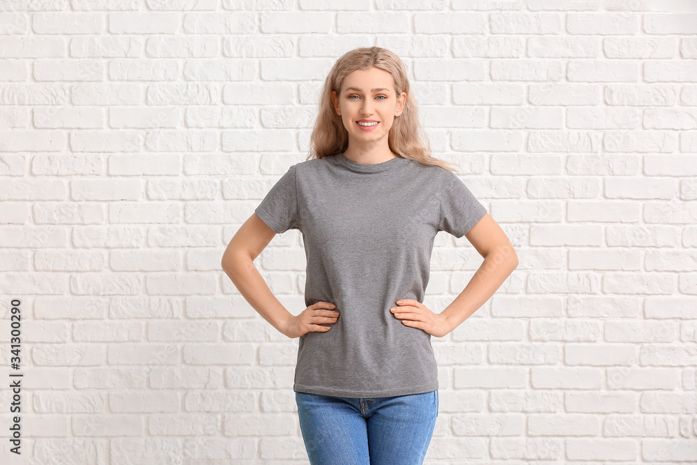 Woman in stylish t-shirt on white brick background Woman in stylish t-shirt on white brick background