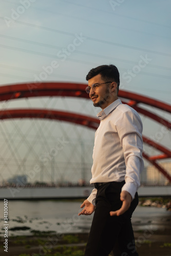Man poses on an old bridge.