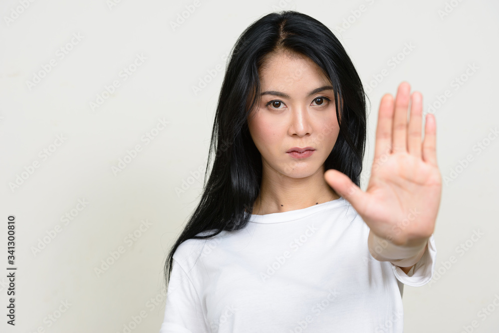 Portrait of stressed young Asian woman showing stop gesture Portrait of stressed young Asian woman showing stop gesture
