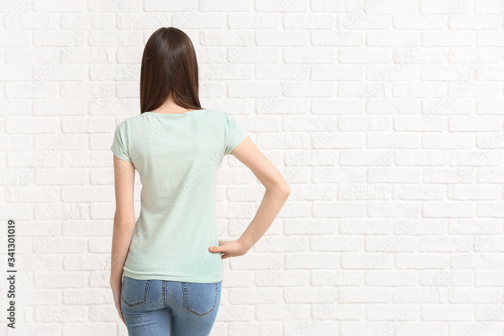 Woman in stylish t-shirt on white brick background