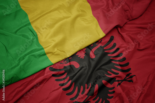 waving colorful flag of albania and national flag of mali.