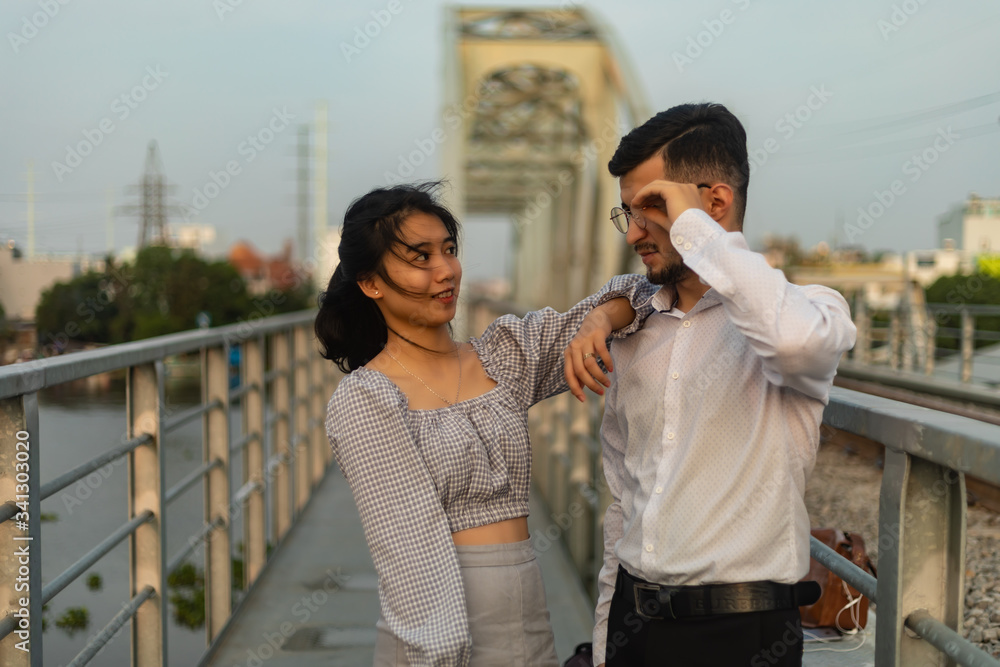 Two people posing on an old bridge in Vietnam.