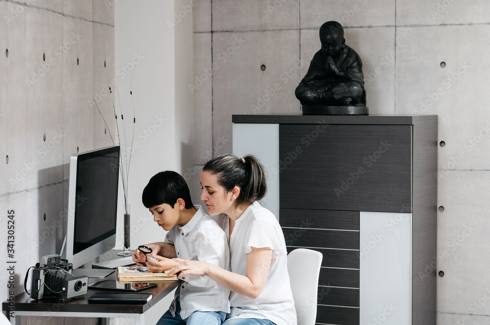 boy studying with his mature mother and looking through a magnifying glass boy studying with his mature mother and looking through a magnifying glass