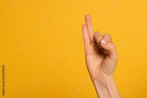 Cropped view of woman using sign language isolated on yellow