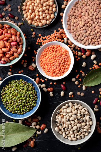 Legumes variety, overhead shot on a black background. Lentils, soybeans, chickpeas, red kidney beans, a vatiety of pulses