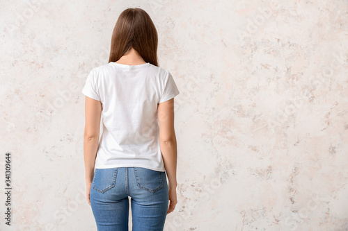 Young woman in stylish t-shirt on light background