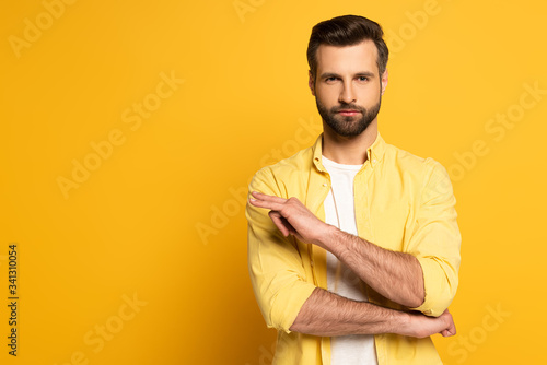 Handsome man showing gesture in deaf and dumb language on yellow background