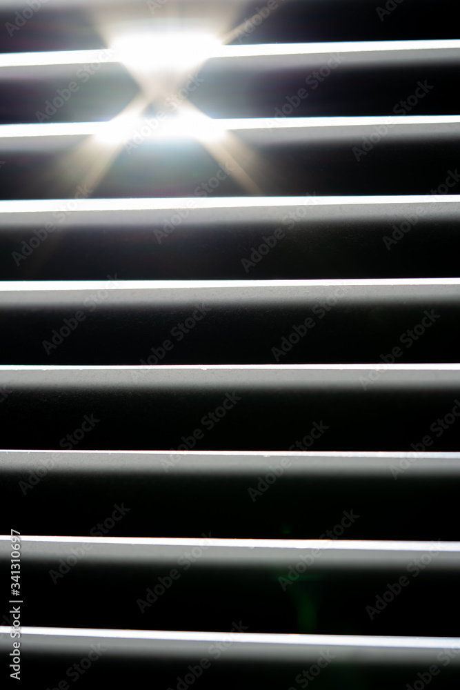 Obraz premium Thin lines of light on the wall. Shadow from the blinds. bathroom.