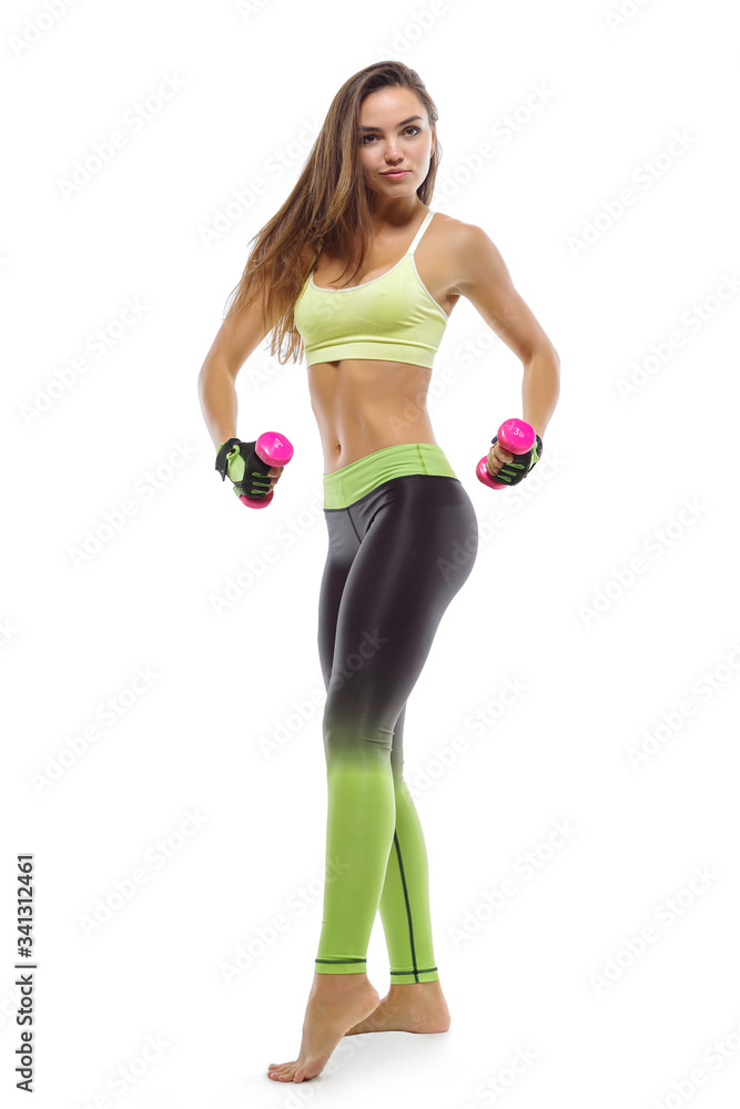 A young girl poses in sportswear on a white background, with dumbbells