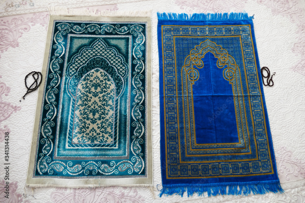 Islamic symbols, blue and green prayer rugs on a carpet in a house,