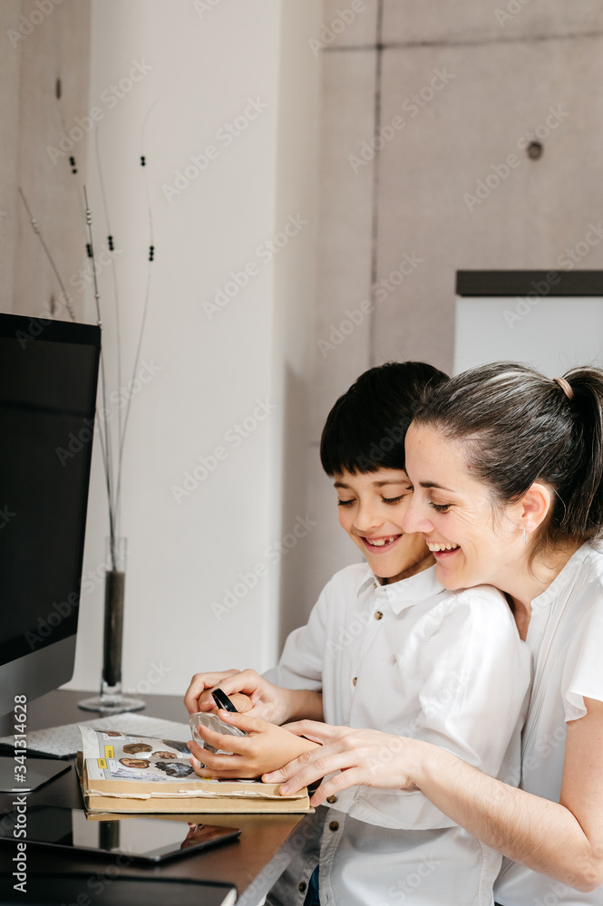 boy studying with his mature mother and looking through a magnifying glass boy studying with his mature mother and looking through a magnifying glass