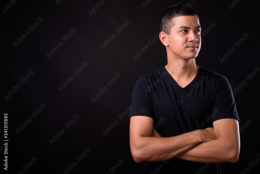 Portrait of young handsome Asian man thinking with arms crossed Portrait of young handsome Asian man thinking with arms crossed