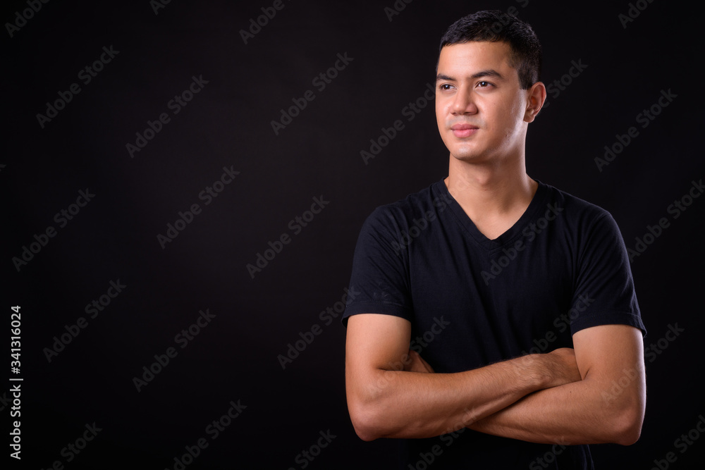Portrait of young handsome Asian man thinking with arms crossed Portrait of young handsome Asian man thinking with arms crossed