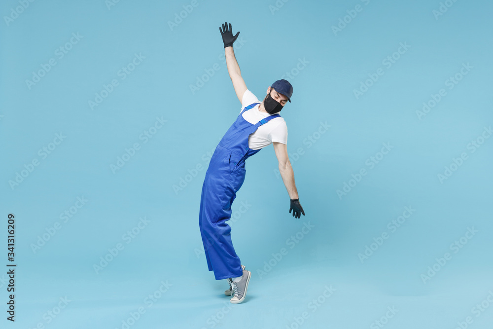 Full length delivery man in cap t-shirt uniform sterile face mask glove isolated on blue background studio Guy employee courier Service quarantine pandemic coronavirus virus covid-19 2019-ncov concept