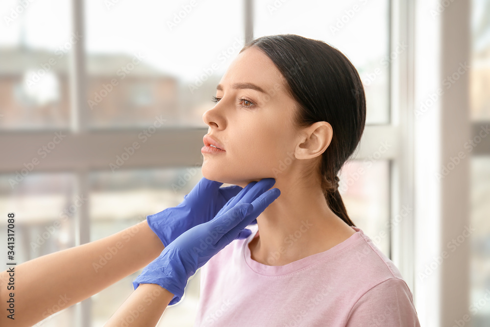 Endocrinologist examining thyroid gland of young woman in clinic Endocrinologist examining thyroid gland of young woman in clinic