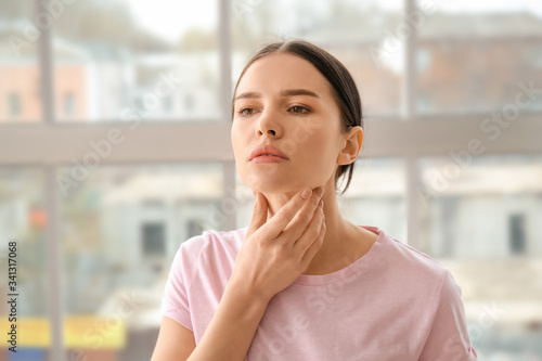Young woman with thyroid gland problem at home photo