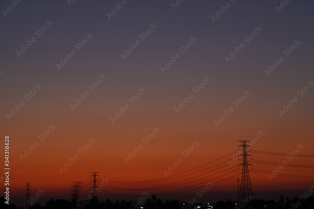 Picture of 3 high-voltage electricity towers during Twilight Life. There is beautiful light. Suitable for use as illustrations of content.