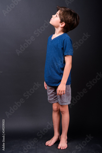 Full body shot of young handsome boy thinking and looking up