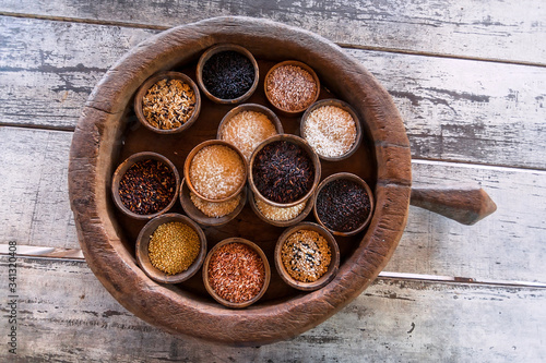 Some colorful rice sorts in wooden pot of asian kitchen. Selective focus basmati, jasmine, berry rice ready for cook. Popular food of South East Asia