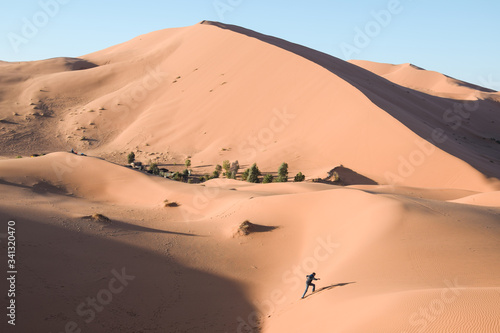 Hombre subiendo por una duna en el desierto del Sahara