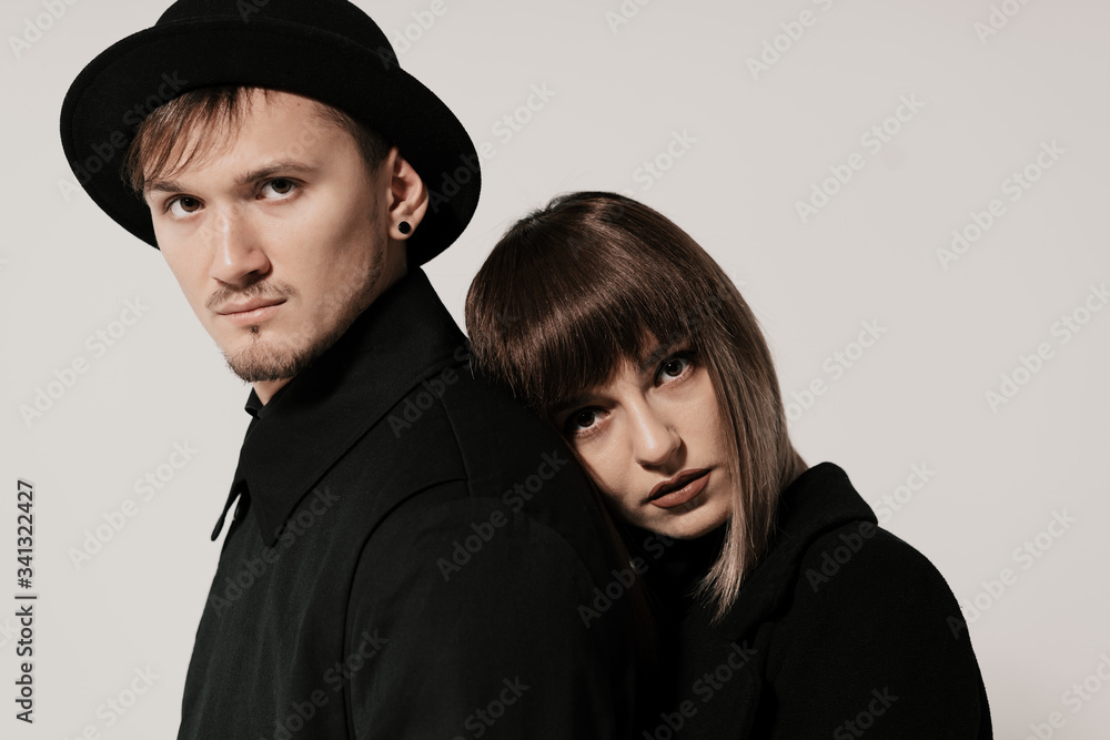 Portrait of urban fashion beautiful couple in black clothes posing over white background together. Close up fashion portrait of stylish young couple pretty woman and handsome man Portrait of urban fashion beautiful couple in black clothes posing over white background together. Close up fashion portrait of stylish young couple pretty woman and handsome man