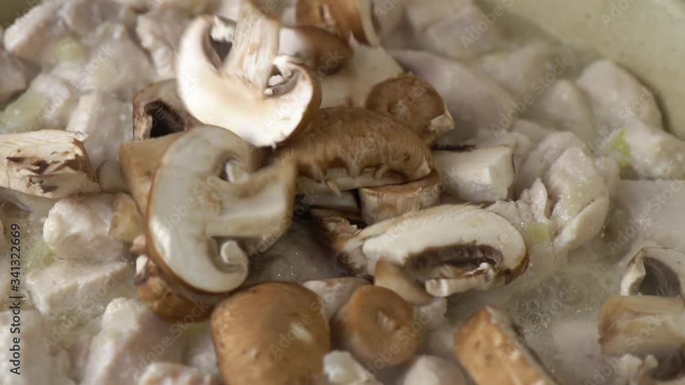 Fresh mushrooms are being added to the frying chicken meat with boiling oil. Fresh mushrooms are being added to the frying chicken meat with boiling oil.
