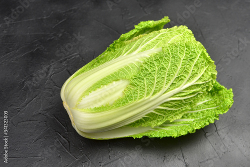 Fresh chinese cabbage head on black background. Vegan food lifestyle. photo