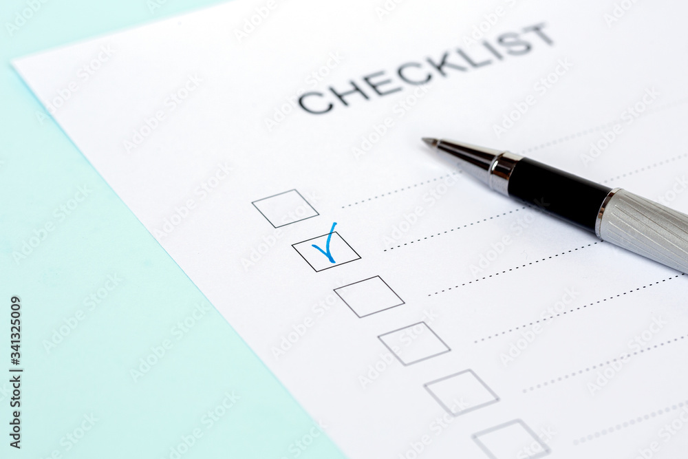 Close-up of on Checklist with pen on a blue background Close-up of on Checklist with pen on a blue background