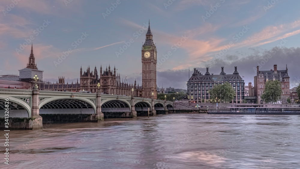 Houses of Parliament with Big Ben and double-decker buses on Westminster bridge at sunset, London, United Kingdom