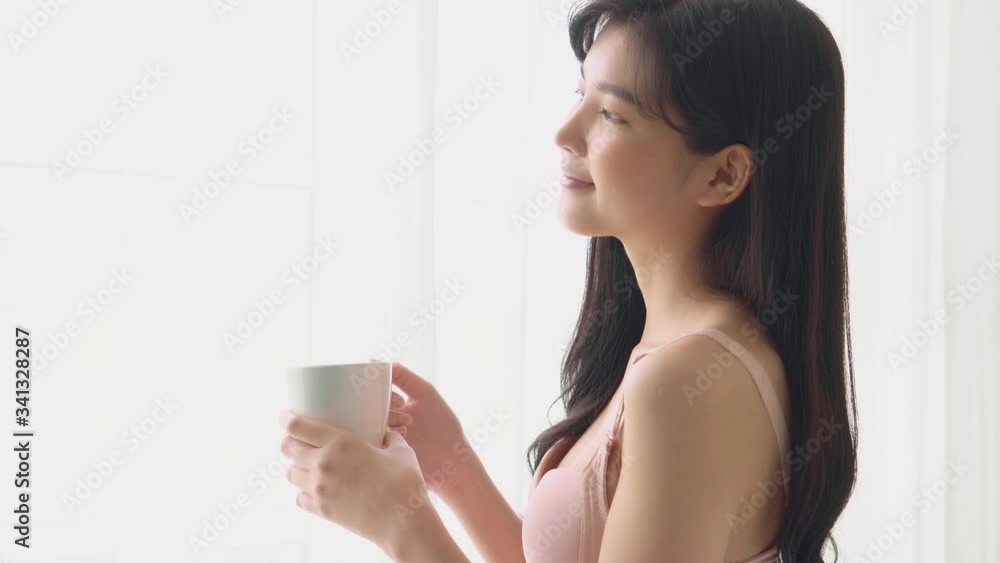 Beautiful young asian woman happy and confident drinking cup of coffee with fresh and looking windows at home, lifestyle asia girl relax in the room at home for wellness and health concept. Beautiful young asian woman happy and confident drinking cup of coffee with fresh and looking windows at home, lifestyle asia girl relax in the room at home for wellness and health concept.