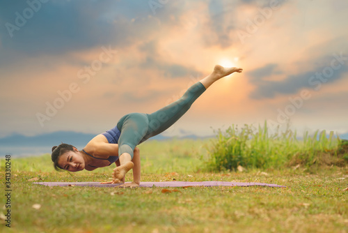 Young girl doing yoga fitness exercise outdoor 
