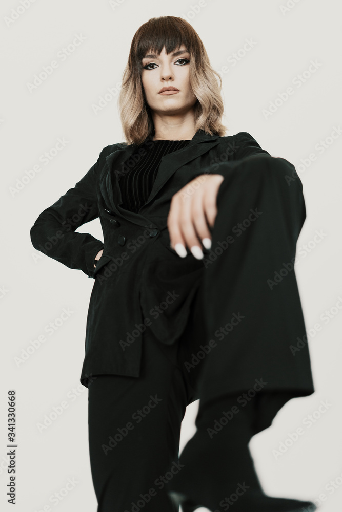 Portrait beautiful bossy woman with attitude wearing black clothes posing on white background looking at camera