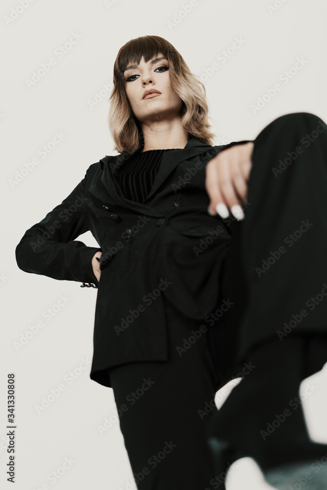 Portrait beautiful bossy woman with attitude wearing black clothes posing on white background looking at camera Portrait beautiful bossy woman with attitude wearing black clothes posing on white background looking at camera