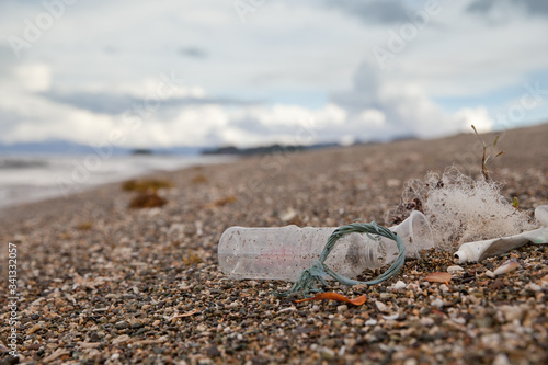 Beach pollution. Plastic bottles and other trash on sea beach. Ocean pollution.